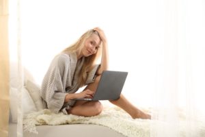 Arische Frau auf dem Bett mit Lerncomputer